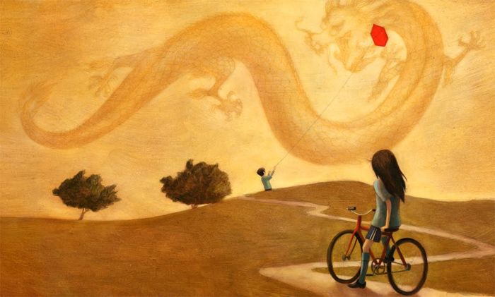 Kvinna på cykel och man med drake