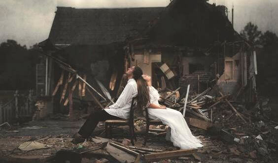 Par framför förstört hus