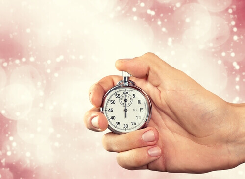 Hand håller klocka