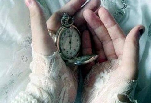 Klocka i kupade händer hos person som försöker kontrollera tiden