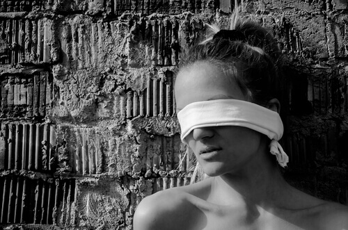 Kvinna med ögonbindel som tror på alternativa psykologier