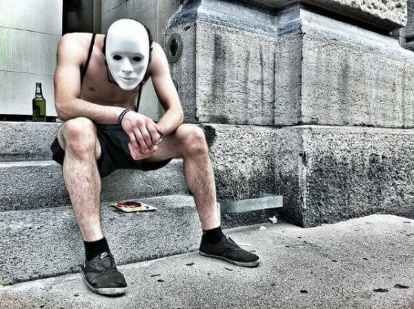 Man med mask som lider av alkoholism