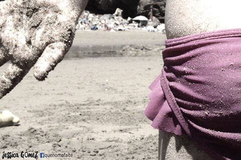 Kvinna på strand som tänker på tjejen i grön baddräkt