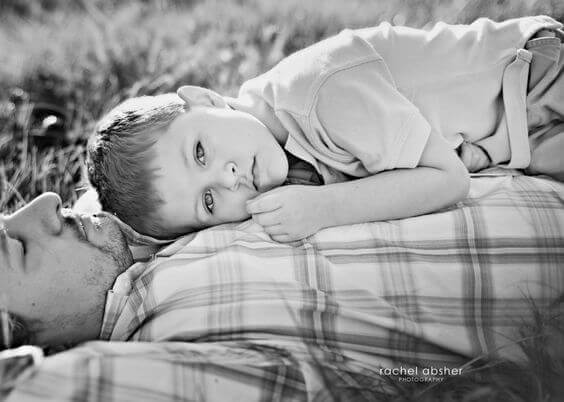 Far och son ligger i gräset