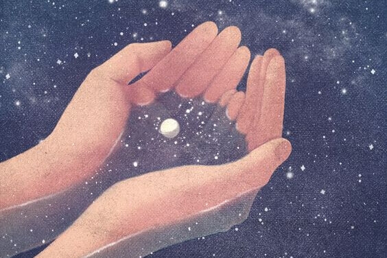 Händer håller universum och stjärnstoft
