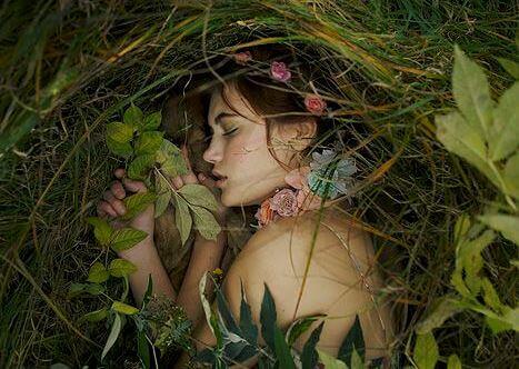 Kvinna som sover bland gräs och drömmer om ormbunken och bambun