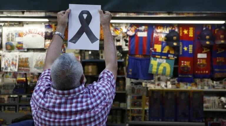 Man som hänger upp svart band efter terrordåd i Barcelona