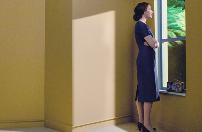 Kvinna som tittar ut genom fönstret