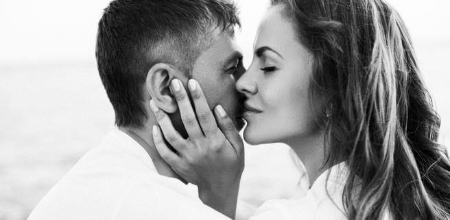 Kvinna som viskar i en mans öra och visar varför vi blir förälskade
