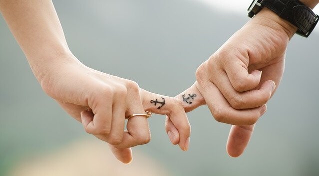 Par som håller finger