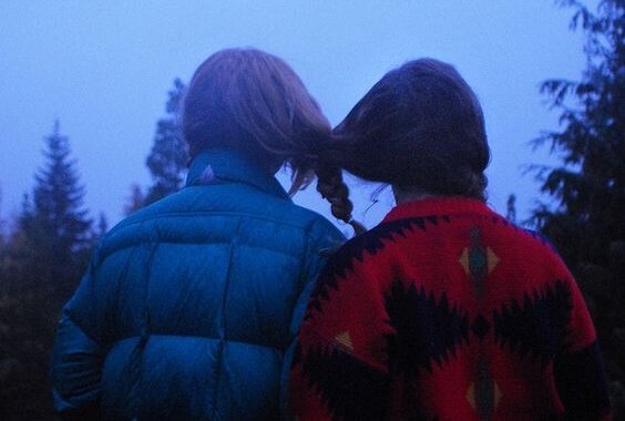 Kompisar med sammanflätat hår som illustrerar emotionellt beroende inom vänskap
