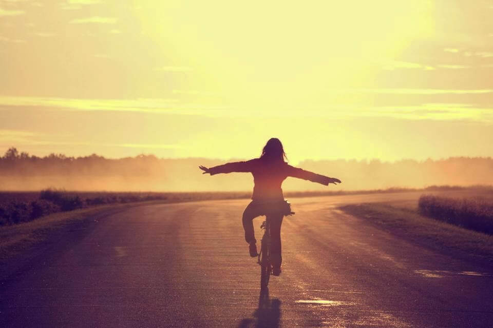 Lycklig kvinna på cykel