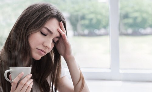 Kvinna med huvudvärk som borde utöva kroppslig medvetenhet