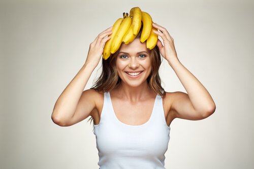 Kvinna med bananer på huvudet som utför en övning som eliminerar skamkänslor