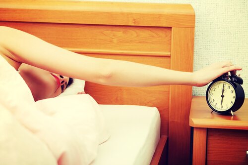 Kvinna som stänger av väckarklocka