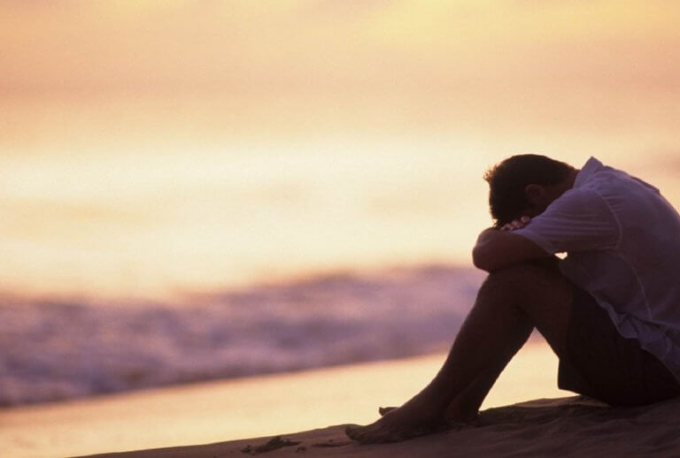 Ledsen man vid strand