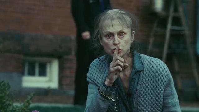 Kvinna som håller finger framför munnen.