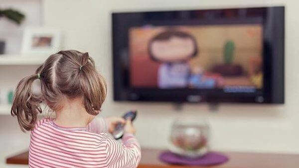 Flicka som ser på TV