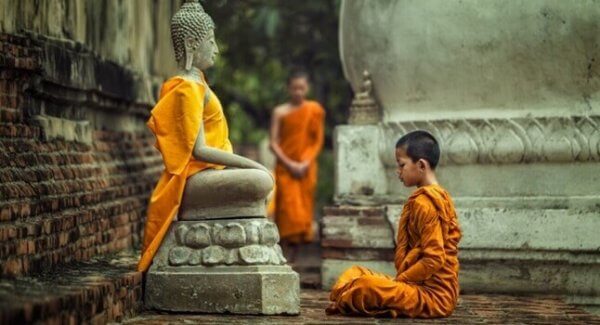 Barn framför Buddha