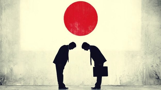 Japanska män som bugar under flagga.