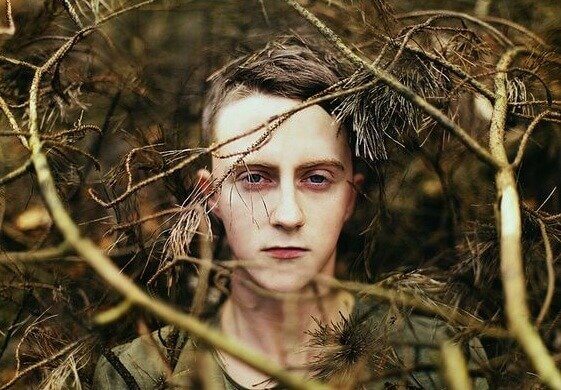 Pojke i skogen som lider av rädsla som maskerar sig som lathet