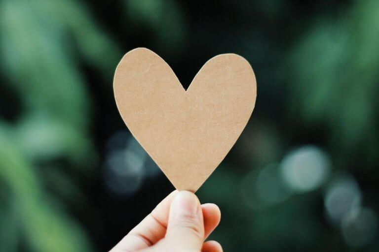 Person som håller i pappershjärta.
