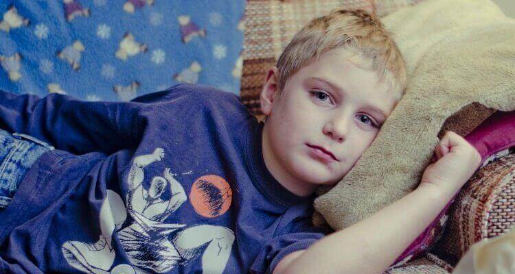 Pojke som ligger i soffan.