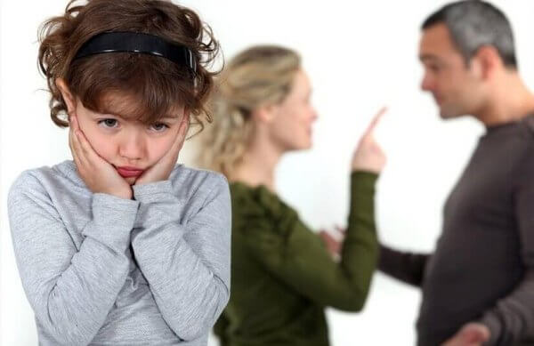 Barn lyssnar på bråkande föräldrar