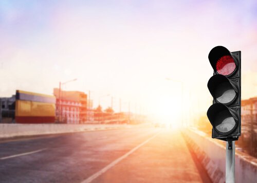 Rött trafikljus i solnedgång