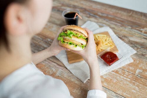 Kvinna äter hamburgare