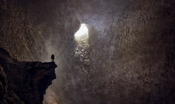 Person i grotta som nått botten men klättrar ut