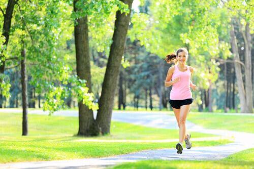 Kvinna som joggar i parken.