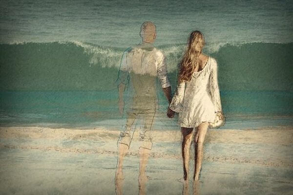 Par som håller hand vid havet.