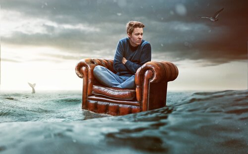Man med social ångest ute på havet i fåtölj