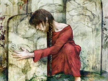 Kvinna kramar gravsten med bild av barn