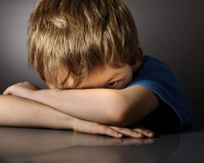 Pojke med slutna armar.