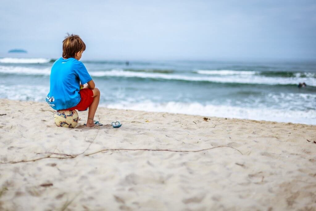 Sörjande pojke på stranden