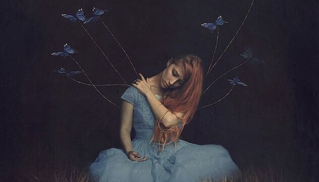Kvinna som är omgiven av fjärilar.