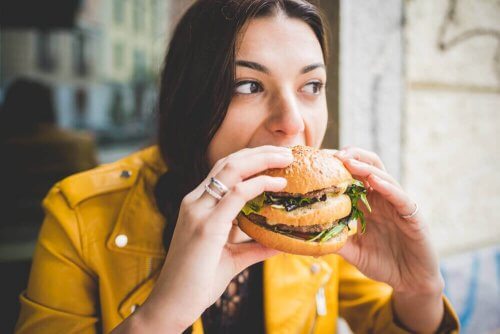 Kvinna som äter hamburgare.