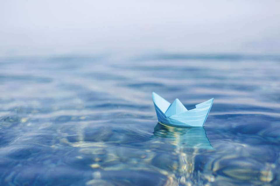 Pappersbåt i vattnet.