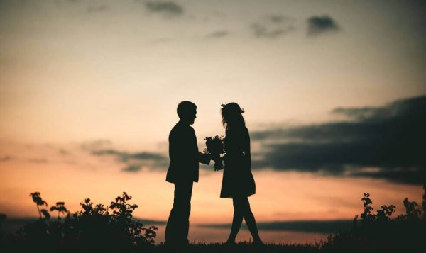 Par utomhus med blommor i solnedgång