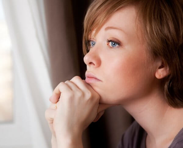 Kvinna som tittar ut genom fönster