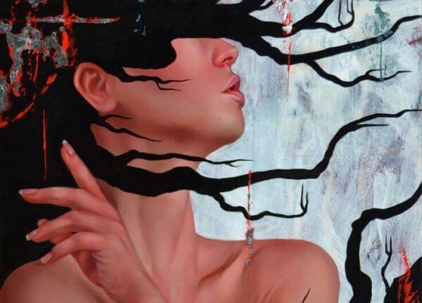 Kvinna som är täckt av svarta grenar.