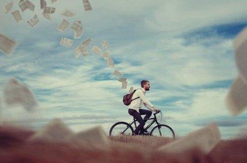 Man cyklar med massor av pappersark som fladdrar ut ur hans ryggsäck