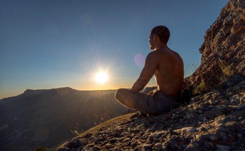 Man mediterar på ett berg