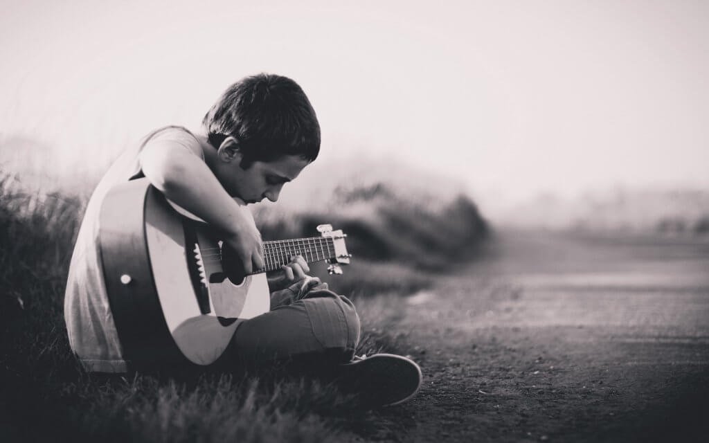 Pojke spelar gitarr