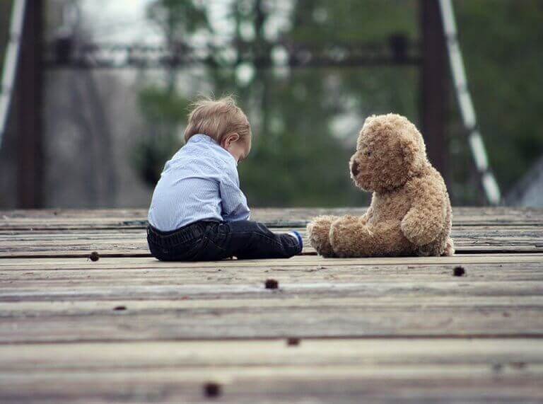 Bebis som sitter med nalle.