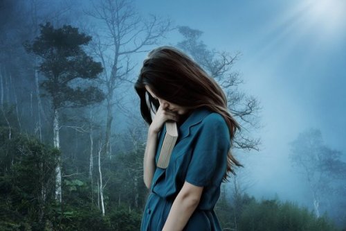 Ensam kvinna i skogen med bok i handen som upplever rädslan att bli övergiven