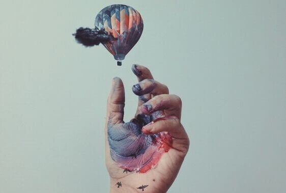 Hand med vattenfärg och liten luftballong