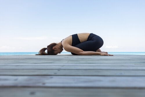 Kvinna gör yogaställningen Balasana